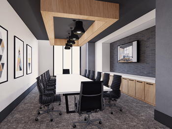 A conference room with a long table surrounded by chairs.